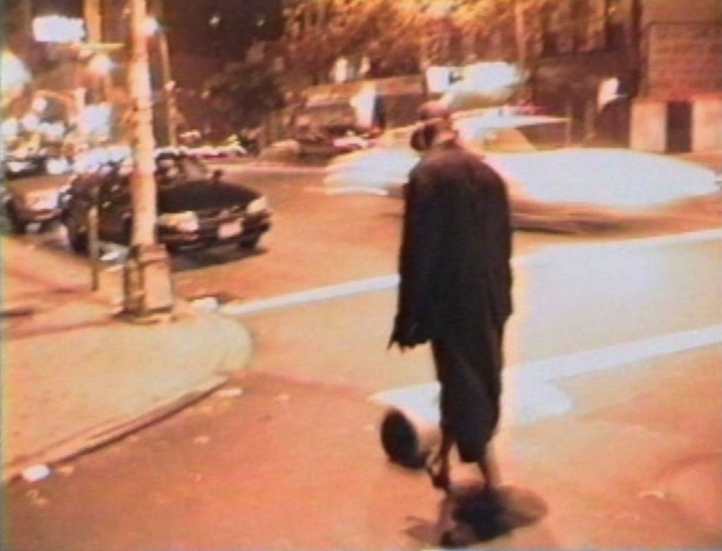 video still of a Black man kicking a can in the street