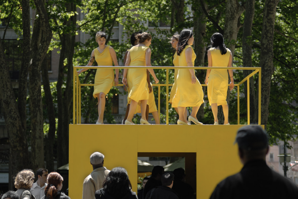 women walking in yellow dresses on a yellow structure