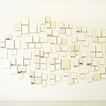 116 small drawings hanging on a wall