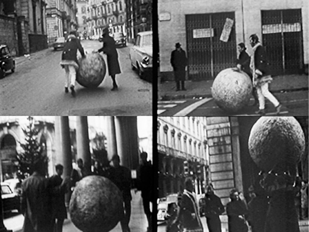 people rolling a large ball in the streets