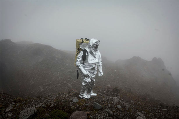 person in protective suit visiting a volcano