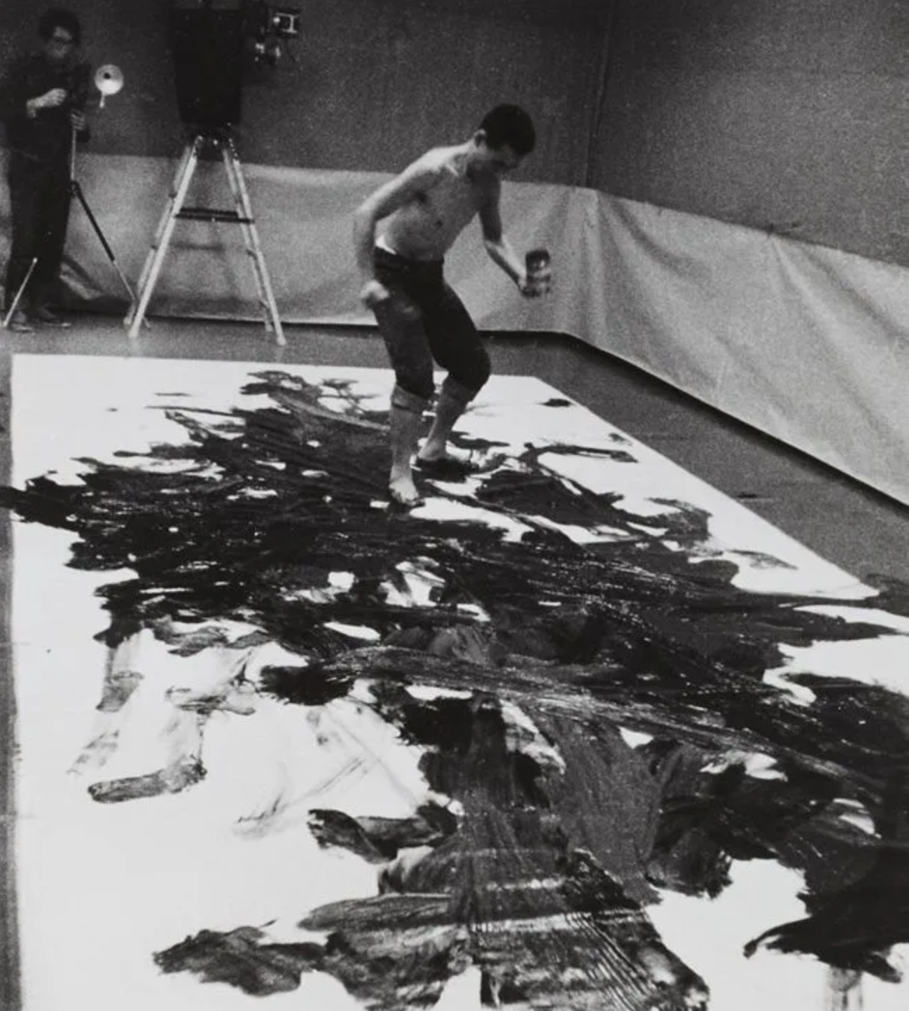 a man painting with his feet on the floor