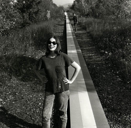 a person standing next to a striped trail