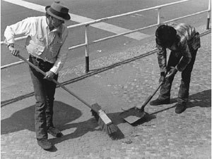 two people sweeping street
