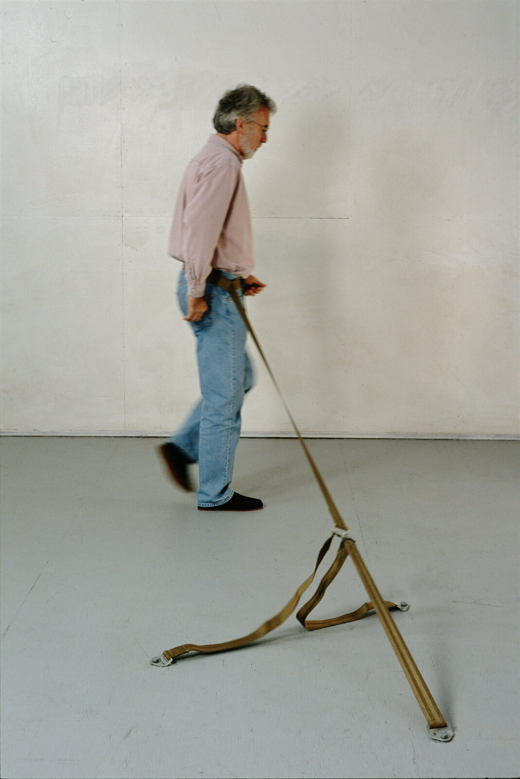 man walking with belt attached to floor