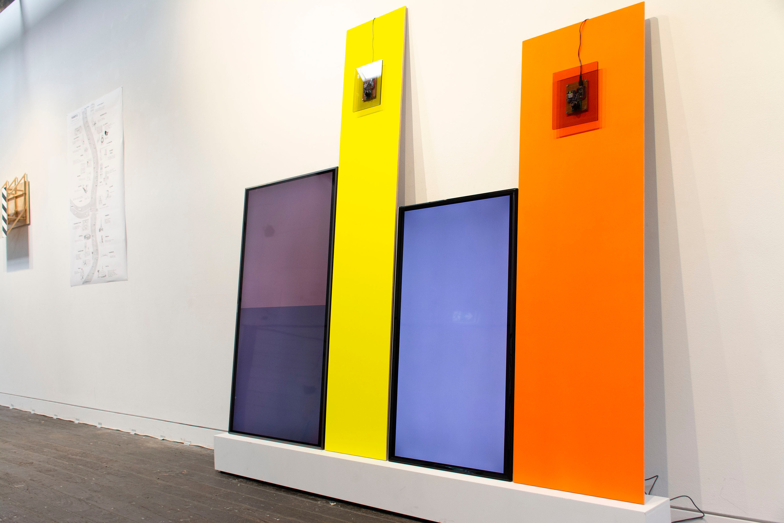 colorful screens leaning against a white wall
