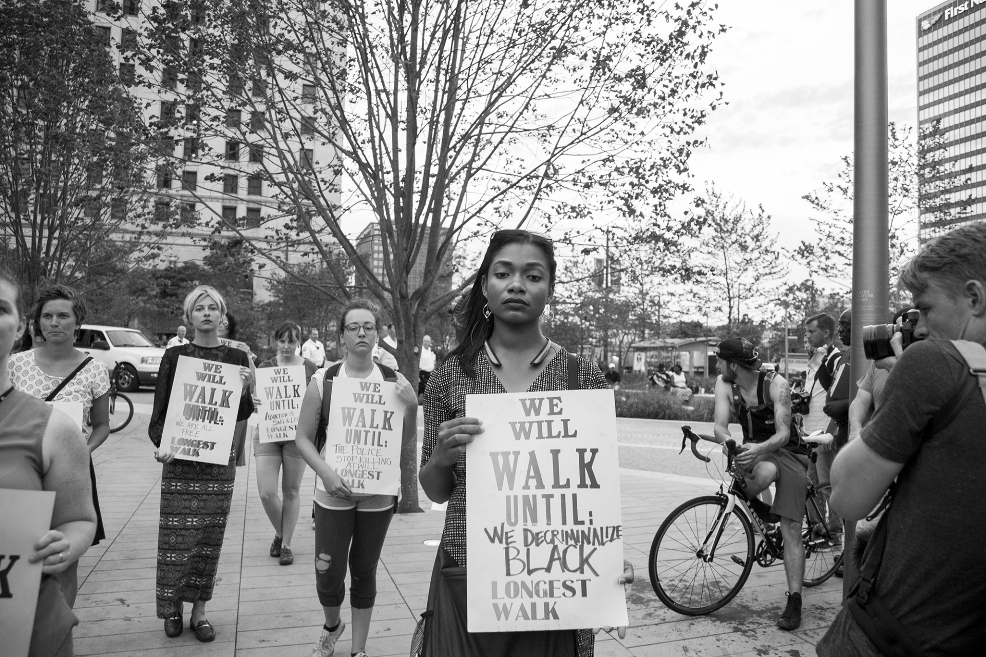 black and white image of people walking with protest signs